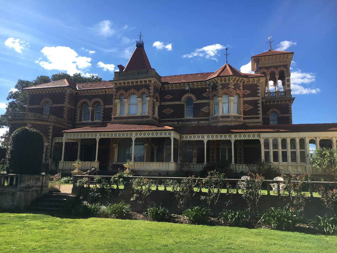 Rippon Lea house, image shows the exterior of the house. The house is made of red brick and looks glamorous.  