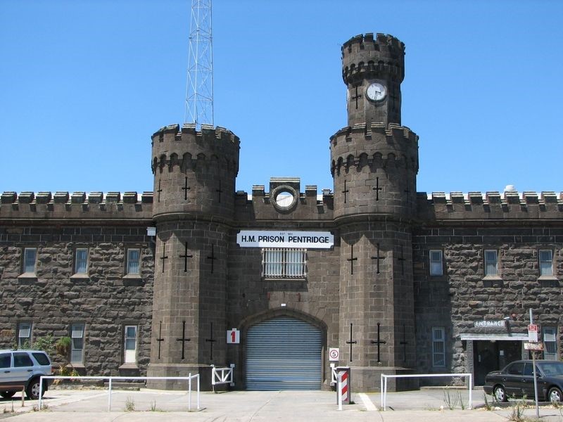 Image shows the entrance to H.M Prison  Pentridge Prison in Coburg. Building is made of grey bricks. 