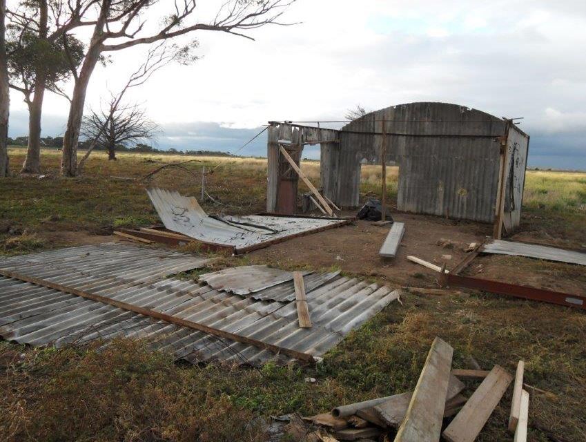 Image shows a broken down hut that has been destroyed by bad weather and time.   