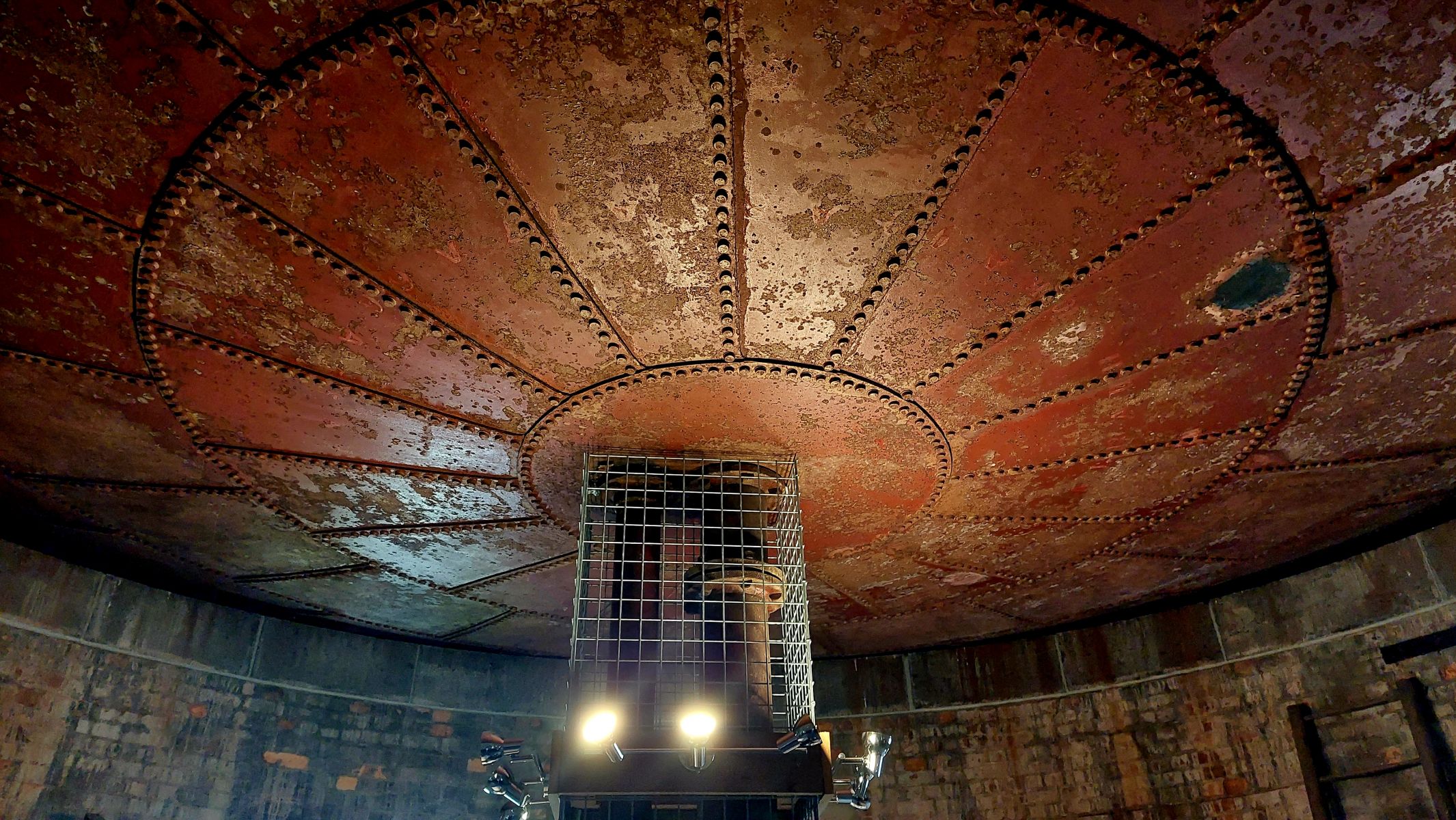 Image shows the inside of the water tower. The base of the tower and roof appears to be made out of black steel. 